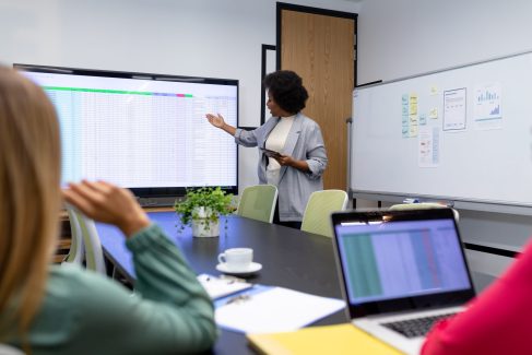 African american businesswoman giving presentation to diverse group of colleagues in meeting room. business in a modern office.