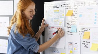 female-web-designer-with-papers-notes-office