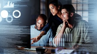 Team of programmers writing digital code in the metaverse and working together on the internet. Group of web designers developing a cybersecurity website, app or software late at night in the office.